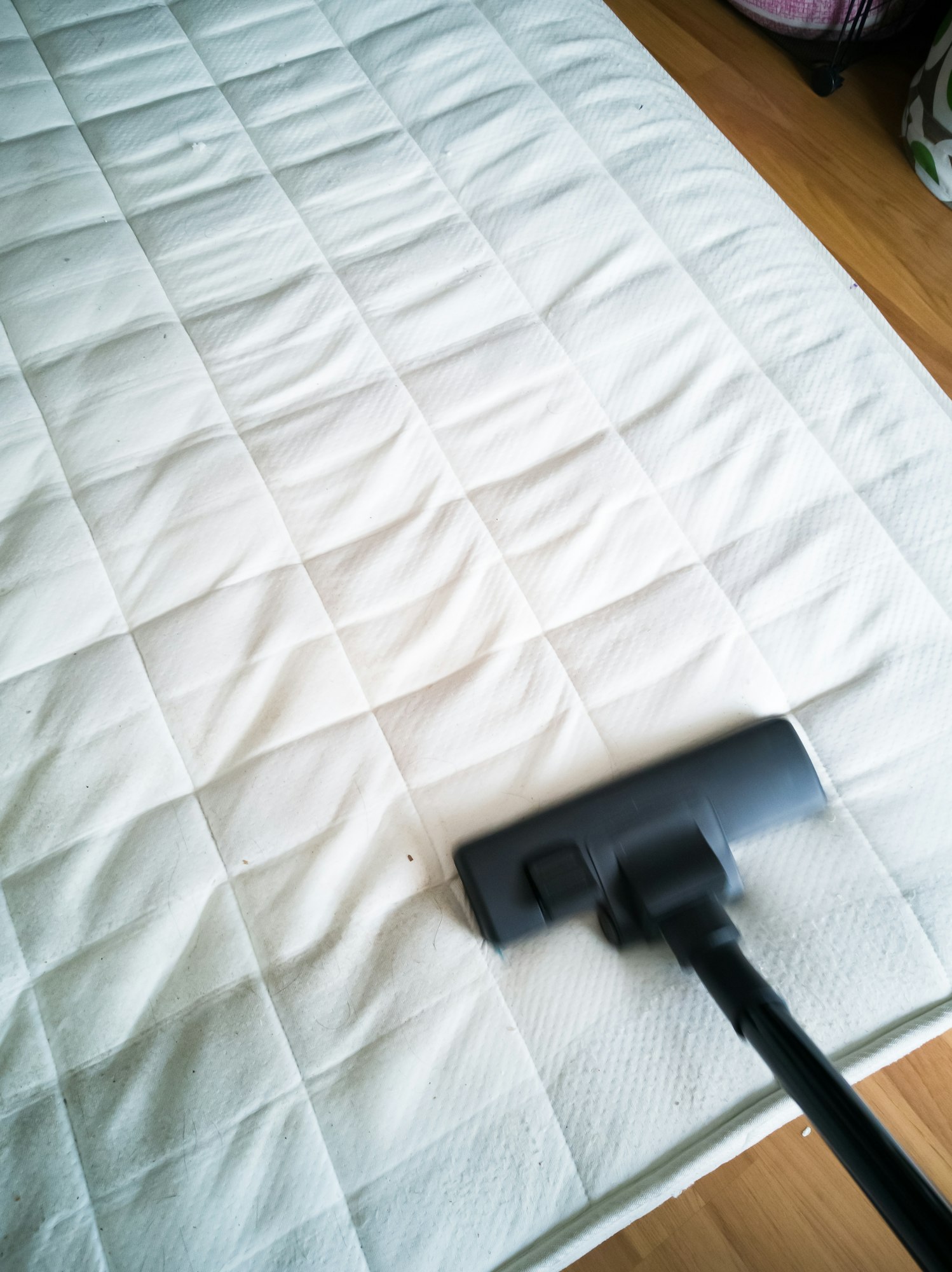 Cleaning the mattress with vacuum cleaner at home.