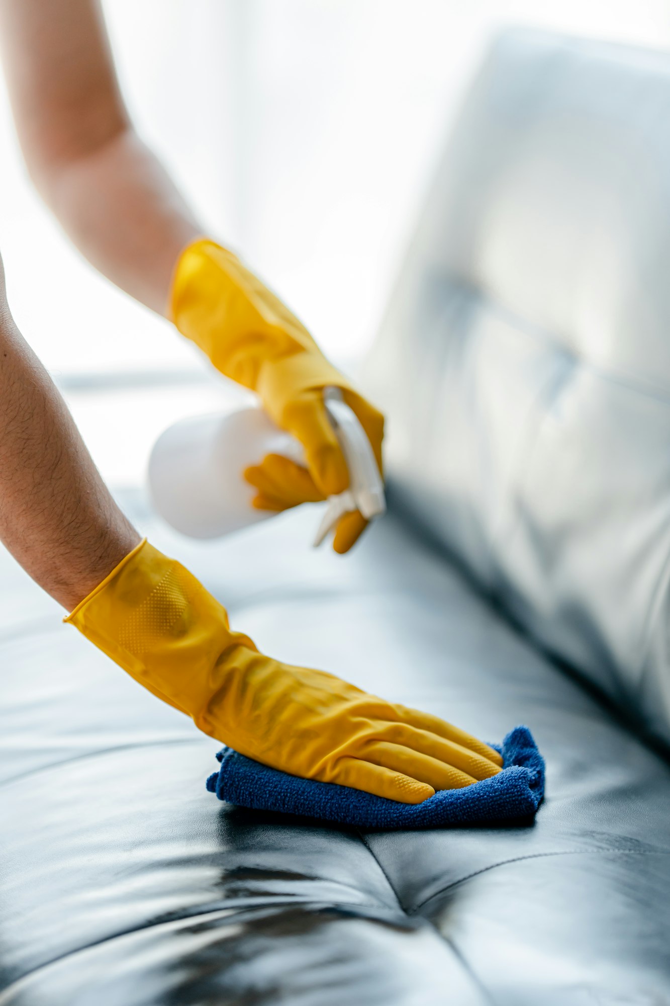 people doing cleaning are using cloths and spraying disinfectant Wipe the sofa in the office room or
